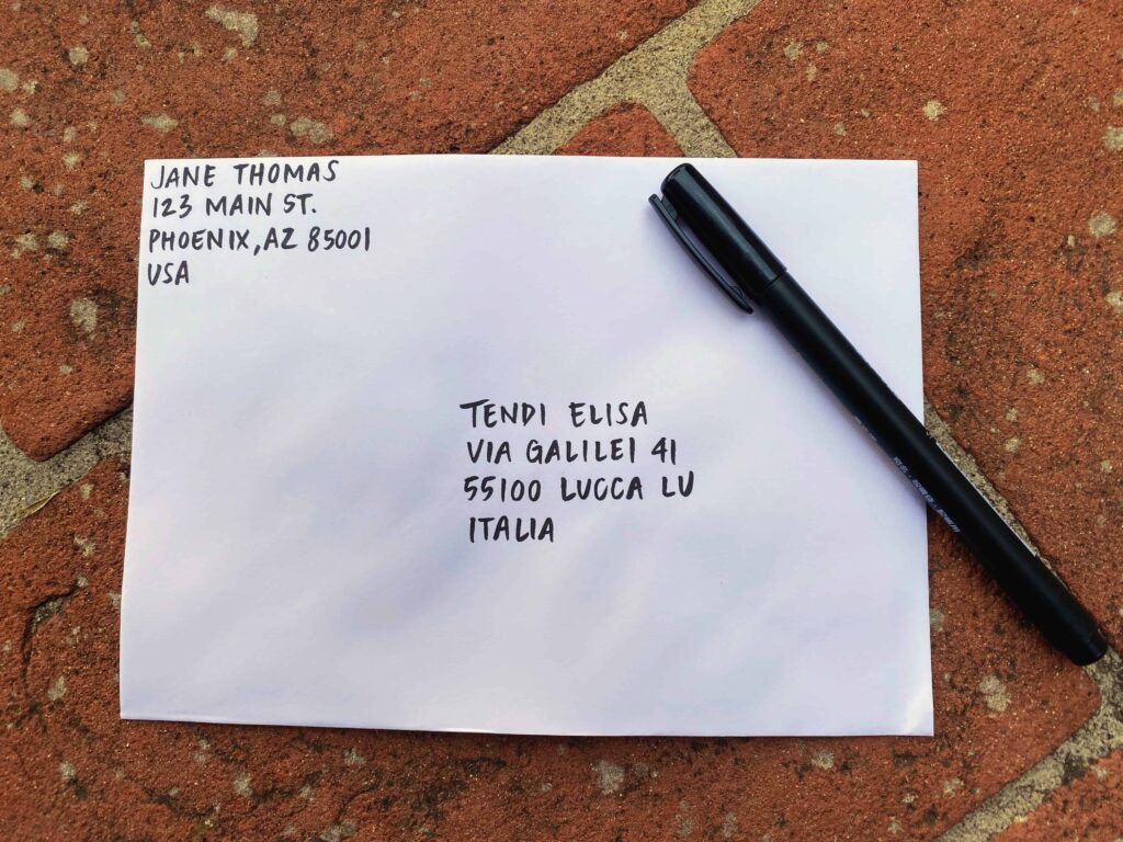 Letter with an Italian address that shows the 5-digit CAP, which is the Italian zip or postal code.  The letter is sitting on terracotta and there is a black pen on the side.