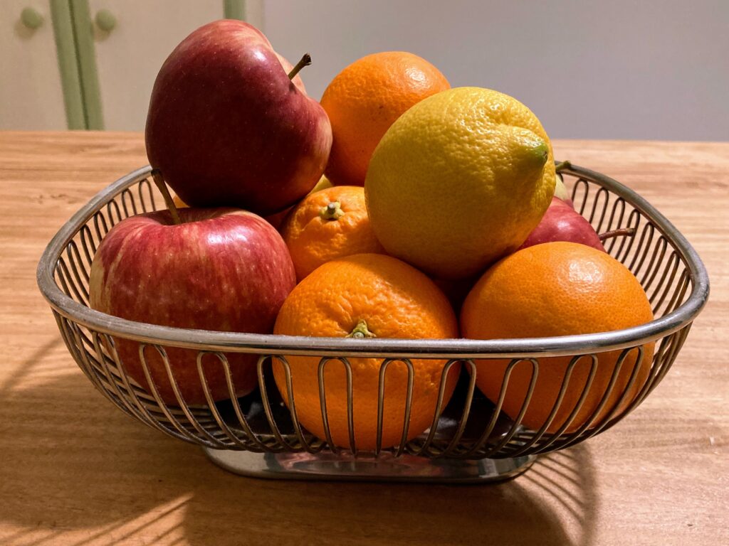 Oranges, apples and lemons sit in an Alessi fruit bowl on a counter in Italy.