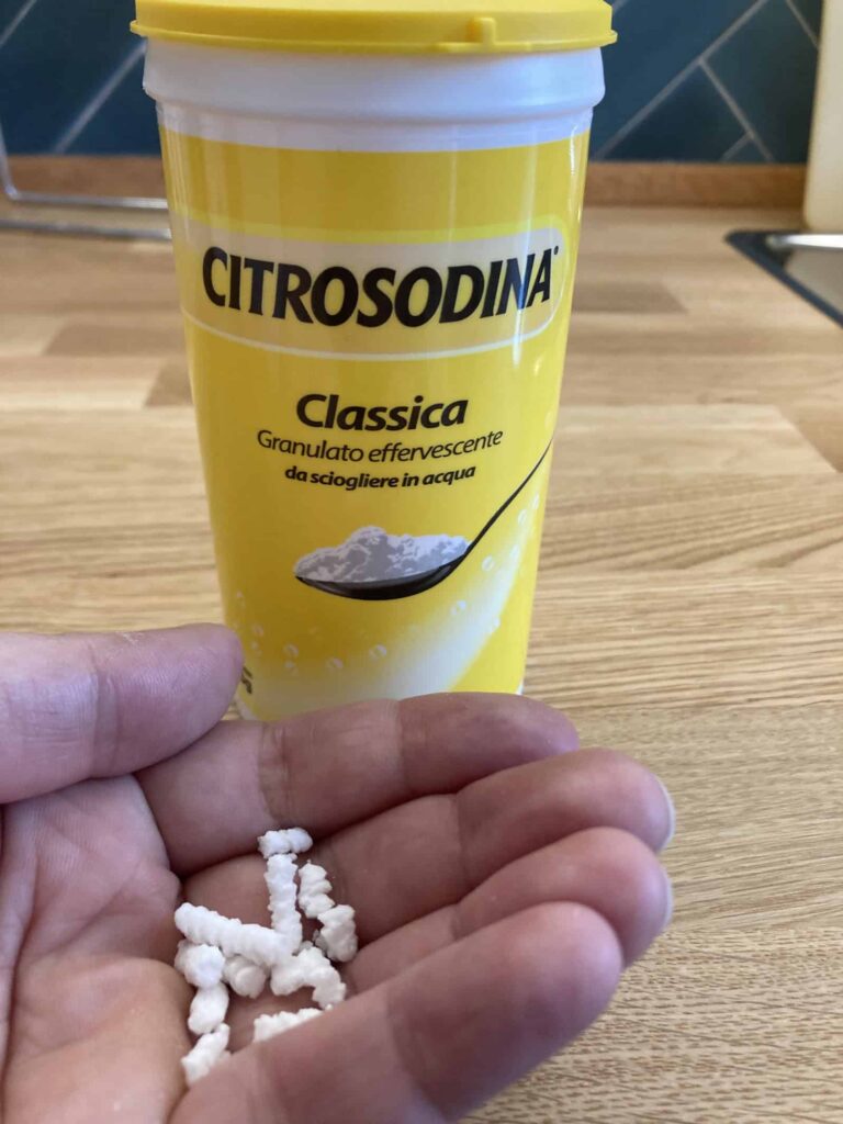 Hand holding citrosodina, an Italian remedy for indigestion.