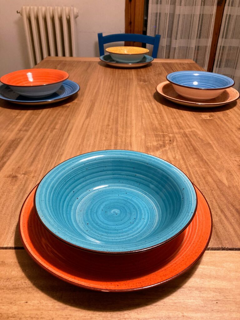 Colorful Tognana (Italian dinnerware brand) plates sitting on a table in Italy.
