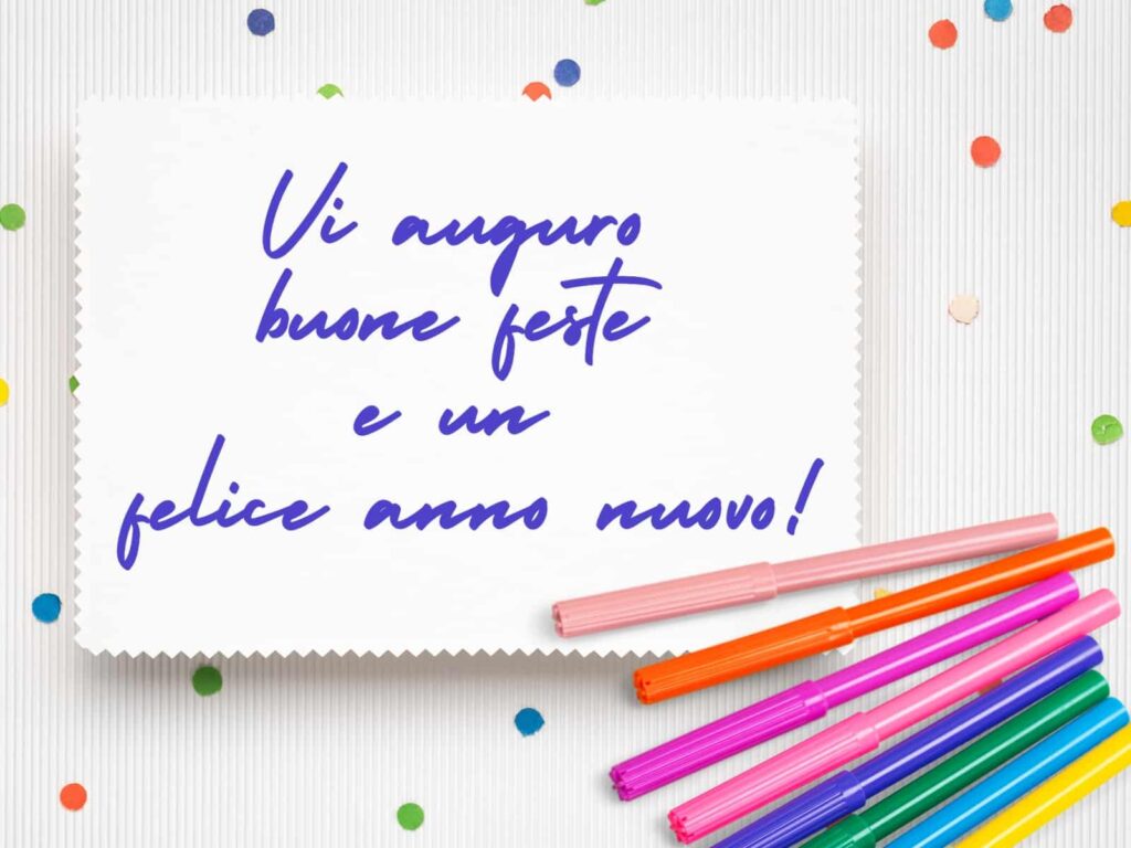 Handwritten new year's card with confetti and colorful markers.  The card says "Vi auguro buone feste e un felice anno nuovo."