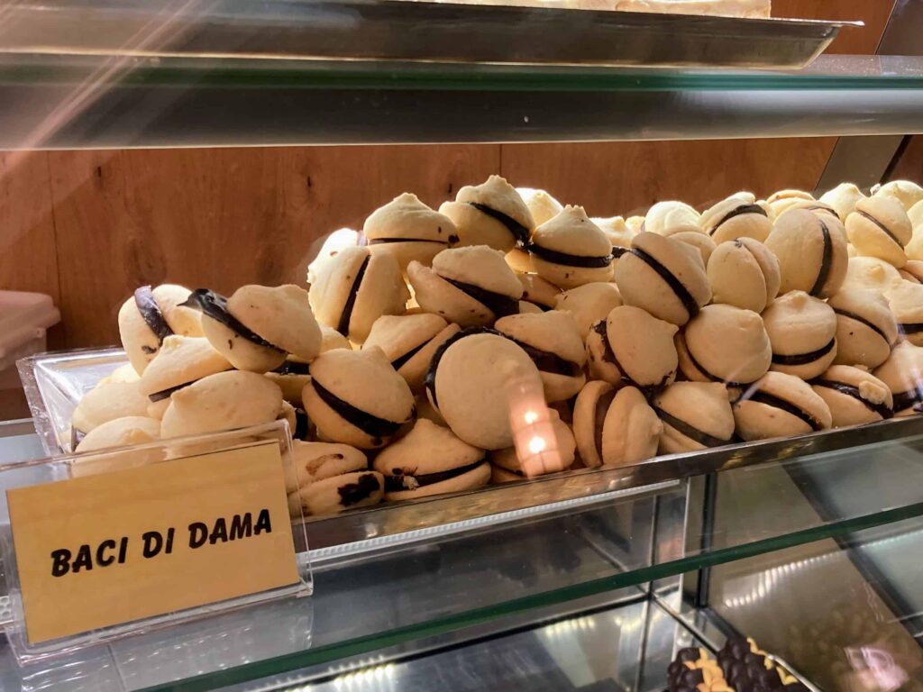 Display of baci di dama cookies and sign in a pastry shop in Italy.