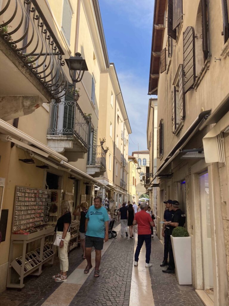 People walking on narrow street in Bardolino, Italy