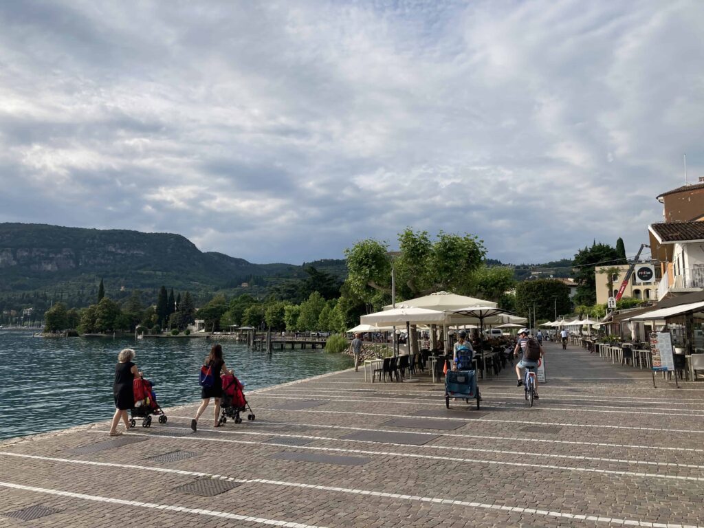 People walking and riding bikes on Lake Garda bike path.