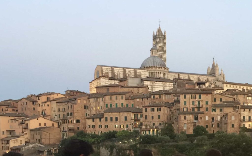 View of buildings of Siena in Tuscany at dusk.