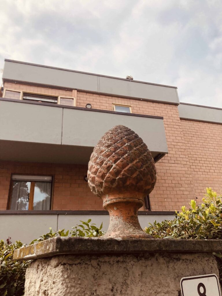 Terracotta pinecone outside an apartment building in Italy.