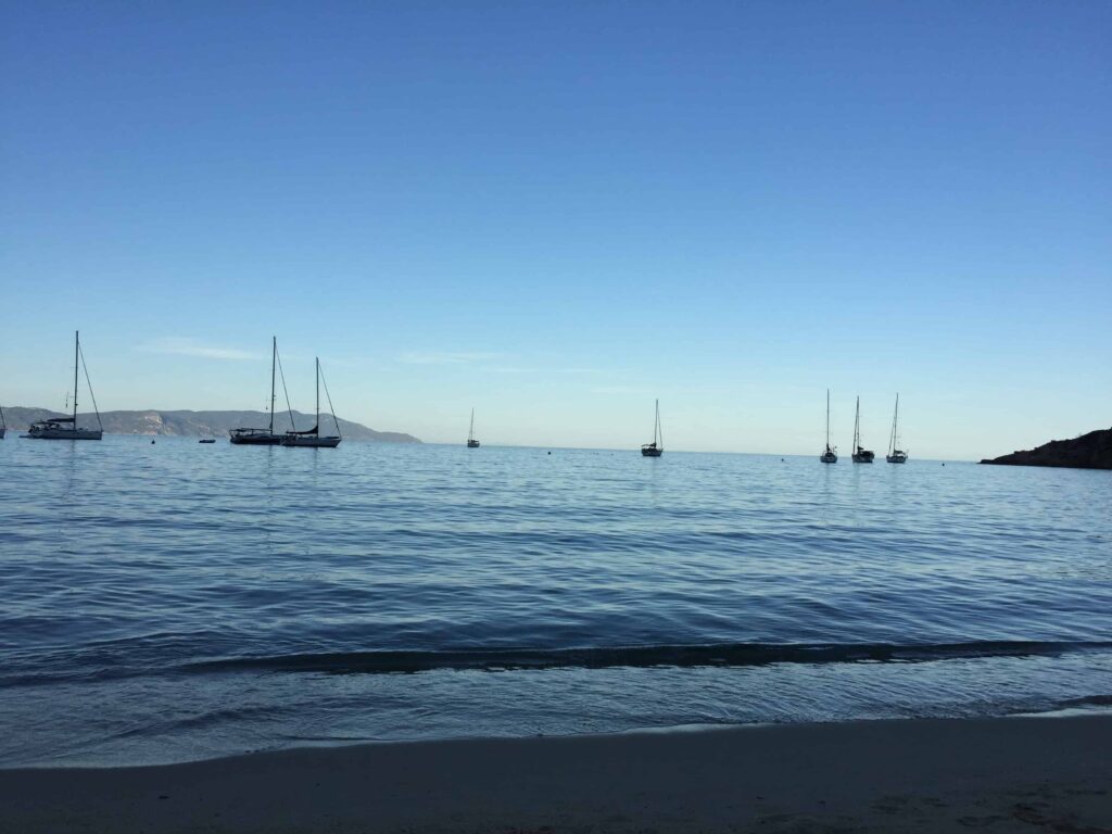 Sailboats sitting on calm water in the Mediterranean Sea.