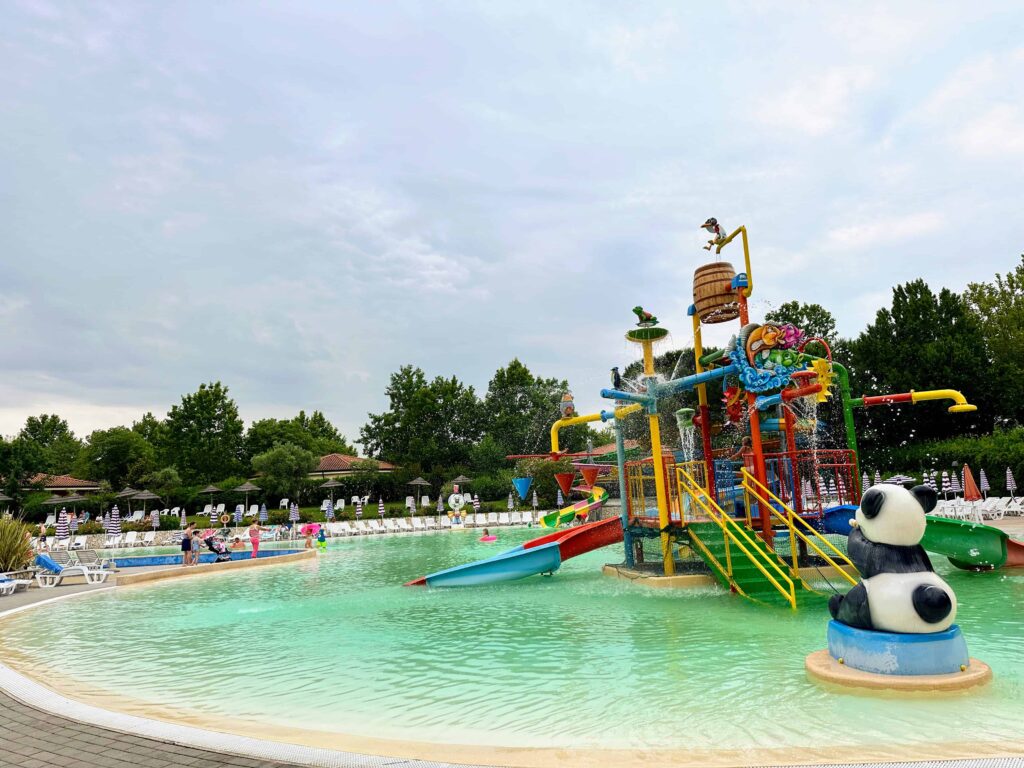 Children's pool with colorful slides and structure at Camping Bella Italia in Italy.