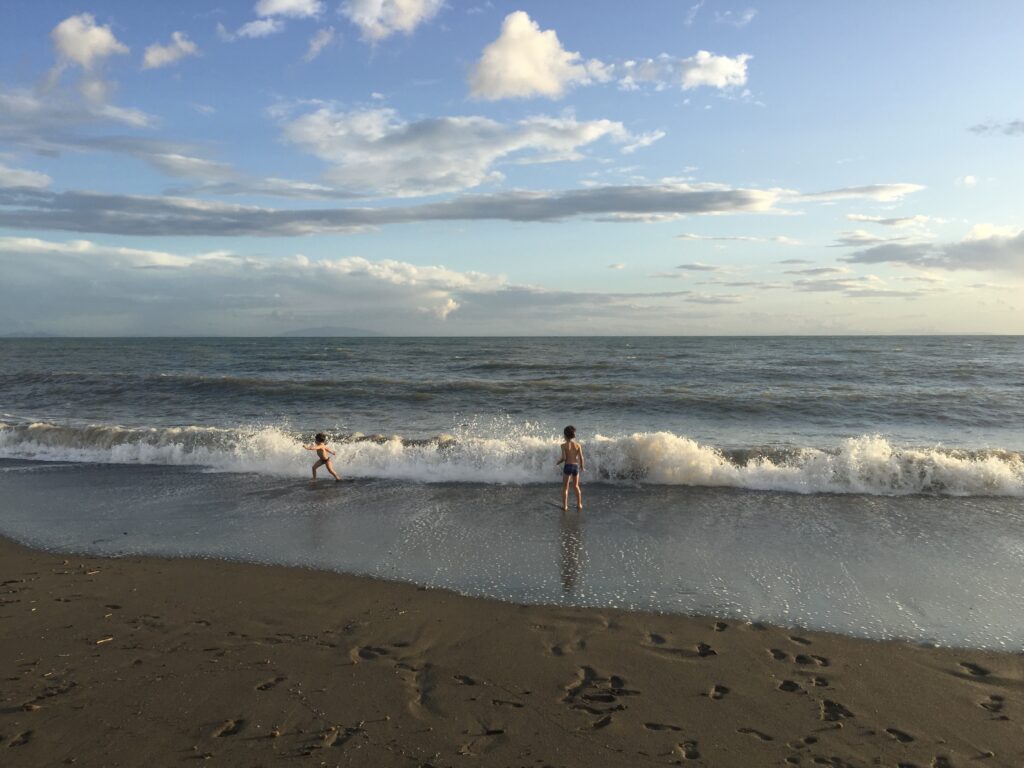 Boys playing in waves at the beach in Cecina, Tuscany