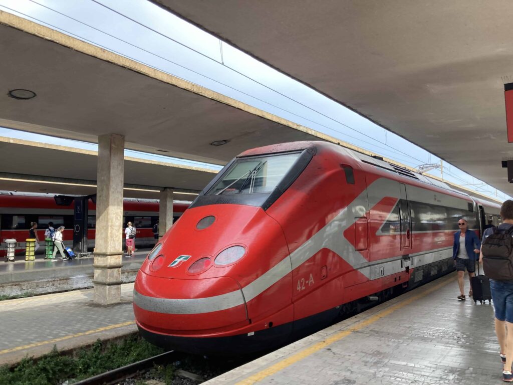 Red Italo train on the track at Florence SMN train station in Italy.