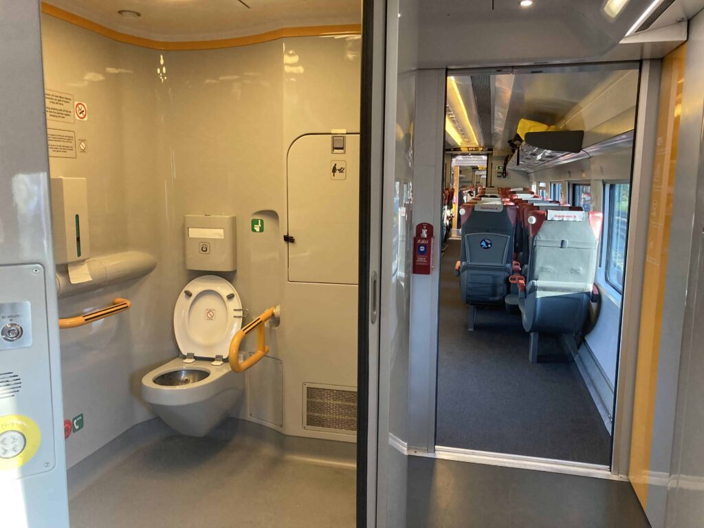 View of bathroom and seats on Italo train in Italy.