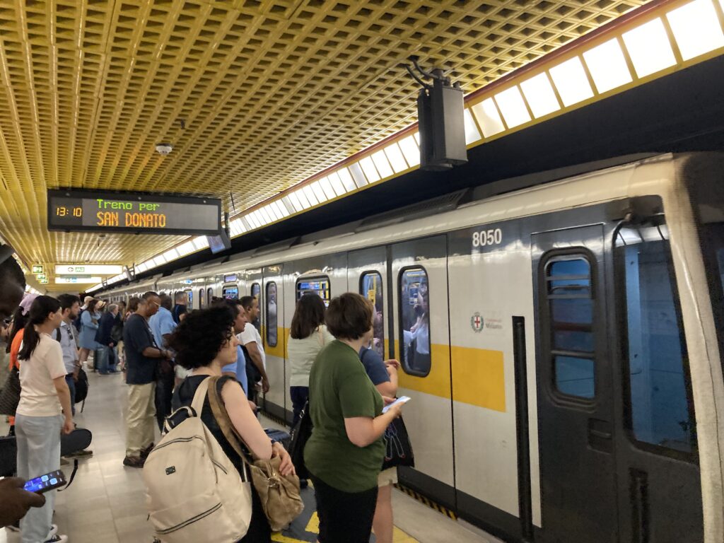 People wait in line to get on the metro in Milan, Italy.
