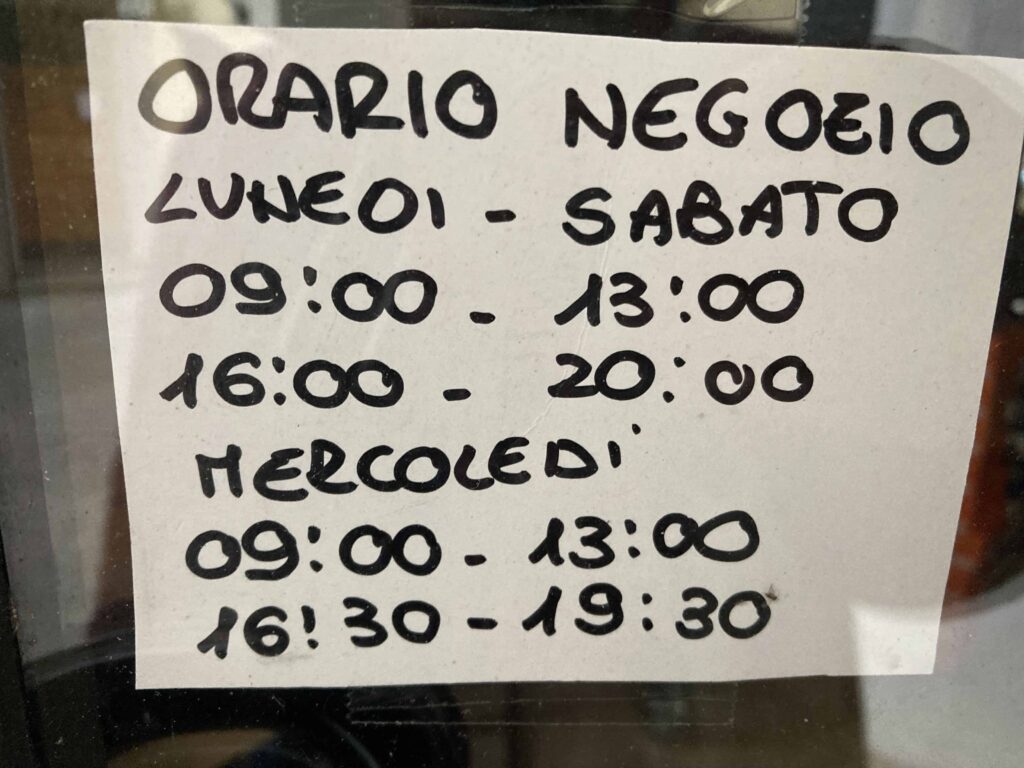 Handwritten sign in Italian with opening days and hours.