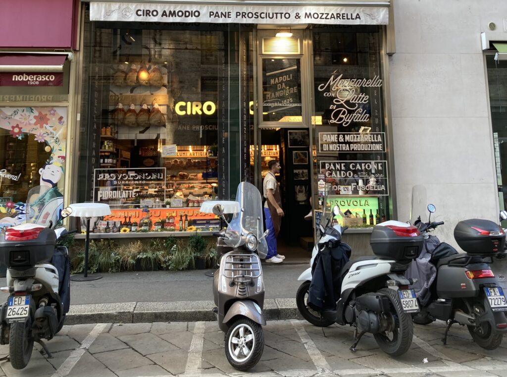 Front entrance to Ciro food shop in Milan, Italy. Glass windows and you can see prosciutto hanging from the walls.