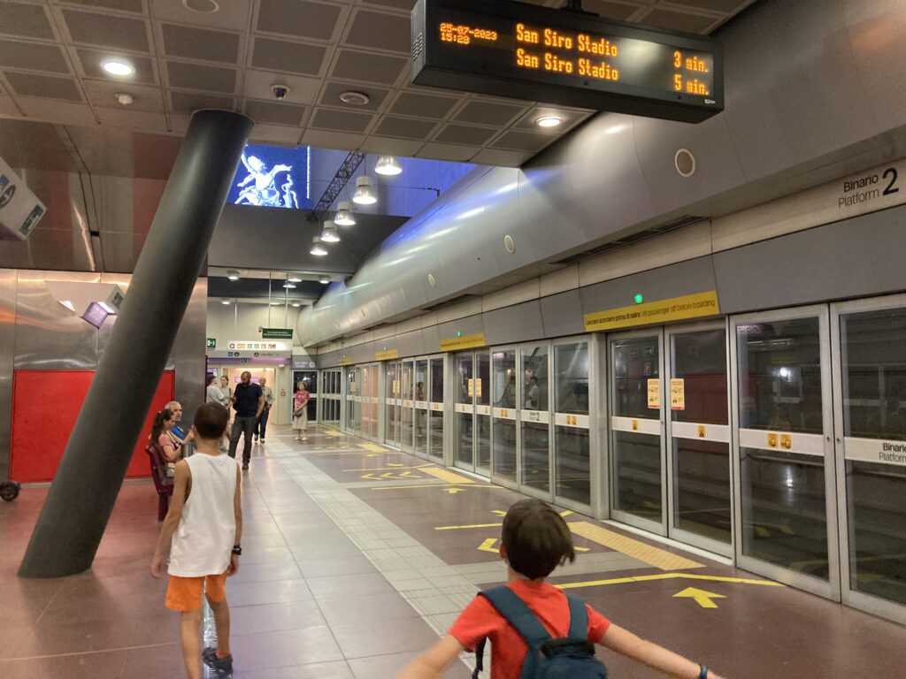 Kids wait on platform for the metro in Milan.